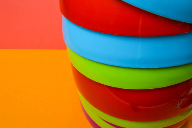 vista stretta di una pila colorata di ciotole di plastica - sfondo colorato astratto - disposable cup cup stack blue foto e immagini stock