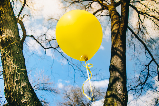 Releasing balloon in blue sky stock photo