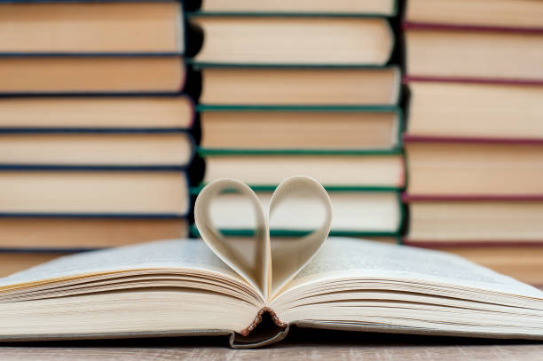 istock Open book, heart made from book sheets.Solid books on a wooden table. Education. 1315692792