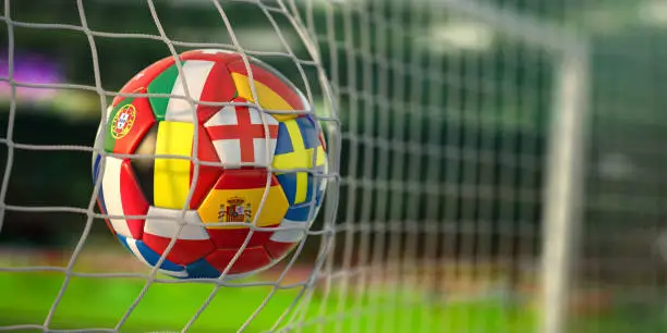 Football ball with flags of european countries in the net of goal of football stadium.  3d illustration
