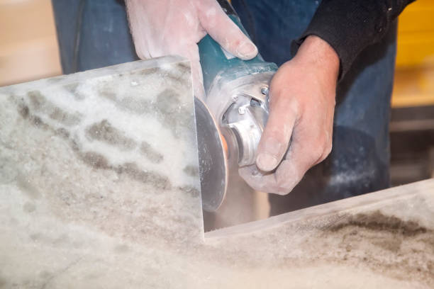 Man making vertical cut with electric hand saw during align marble kitchen countertop at construction site. marble cutting with grinding cutter