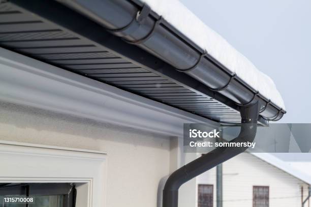 Corner Of The House With New Gray Metal Tile Roof And Rain Gutter At Winter Metallic Guttering System Guttering And Drainage Pipe Exterior Stock Photo - Download Image Now