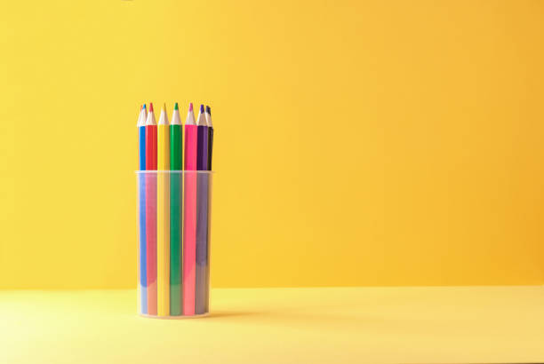 istock Colored pencils in a plastic cup on a yellow-orange background. 1315710218