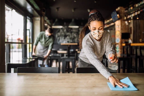 istock Female cafe worker spraying and disinfecting, getting ready for reopening 1315711933