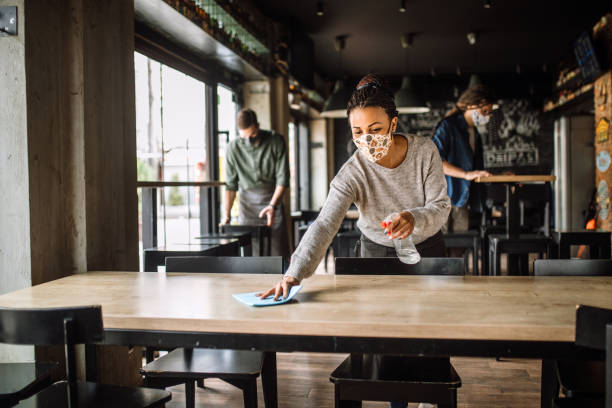 istock Female cafe worker spraying and disinfecting, getting ready for reopening 1315712019