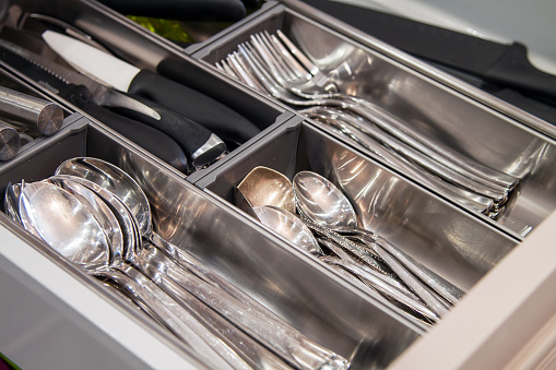 Close up view of opened kitchen drawer with cutlery