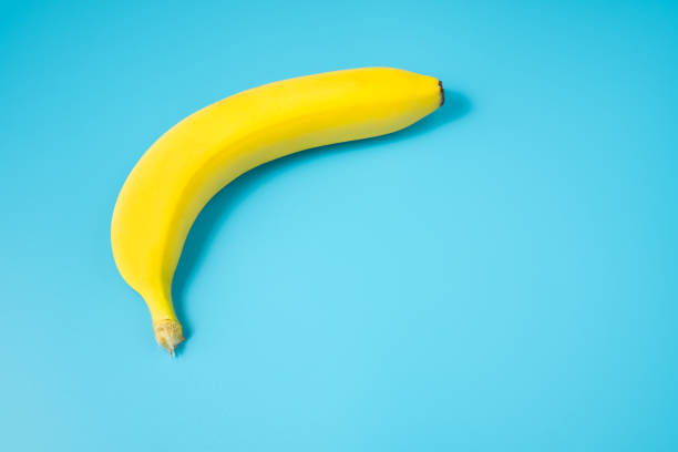 istock Single yellow ripe banana on blue background. Delicious and nutritious snack. 1315716359