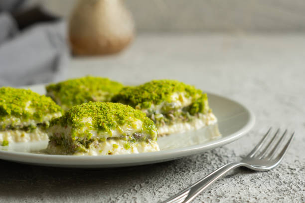 istock Traditional turkish new dessert cold milky baklava with pistachio on white rustic table,  ramadan or holiday desserts concept 1315722379