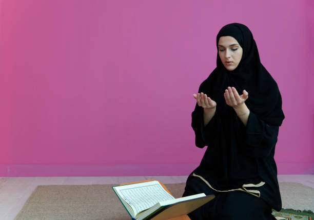 istock Middle eastern woman praying and reading the holy Quran 1315736724