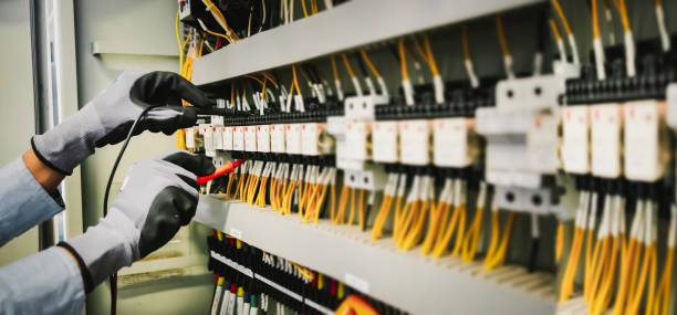 istock Electrical engineers test electrical installations and wiring on protective relays, measuring them with a multimeter. 1315755284