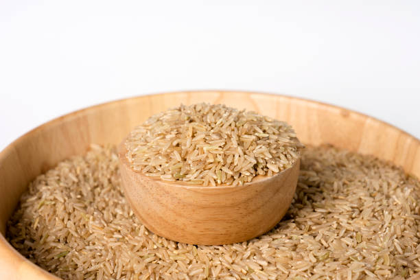 istock Raw brown rice in a bowl on white background. Selective focus. 1315763347