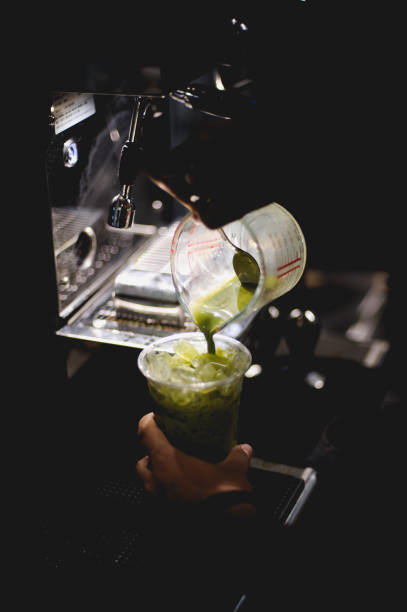 The barista is pouring the coffee mixture.