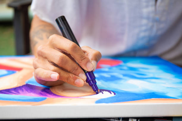 istock Close up of a tattooed arm drawing on canvas 1315765876