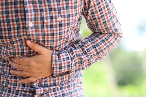 Hombre con dolor de estómago doloroso, gastritis crónica o hinchazón abdominal photo