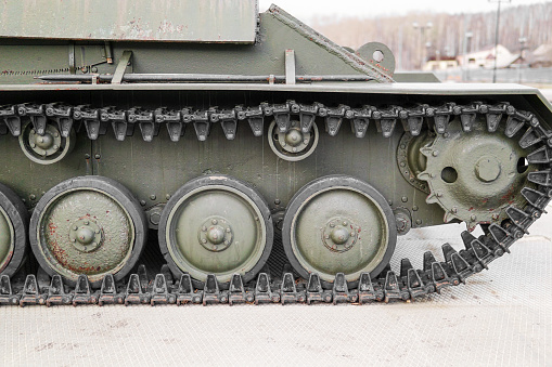 Tank tracks. Tank of the Second World War. Track armor close-up. Black track link and large rubberized rollers. Tank chassis. The tank stands on a pedestal.Russia, May 9, 2021. Detail of a tracked tank close-up