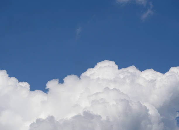 istock A huge white cloud with shadows in a clear dark blue sky. An airy natural background. Free space for text. 1315794006