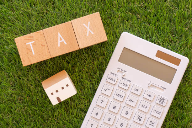 税金;コンセプトの「tax」テキスト、家のおもちゃ、電卓を持つ3つの木製ブロック。 - 税金 ストックフォトと画像