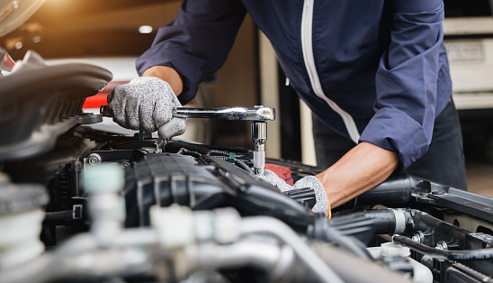 Reparador mecánico de automóviles entrega la reparación de un taller automotriz motor de automóvil con llave inglesa, servicio de coche y mantenimiento, servicio de reparación. photo