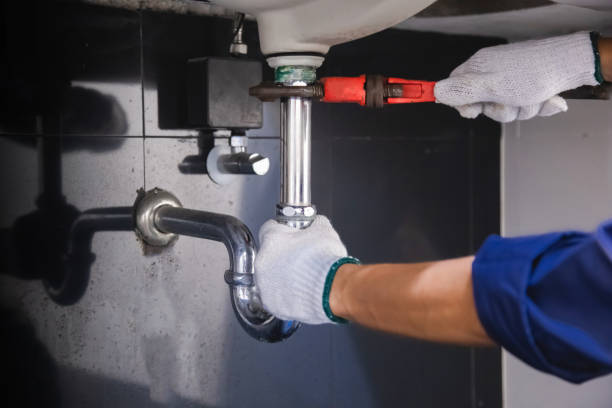 istock Plumber fixing white sink pipe with adjustable wrench. 1315800190