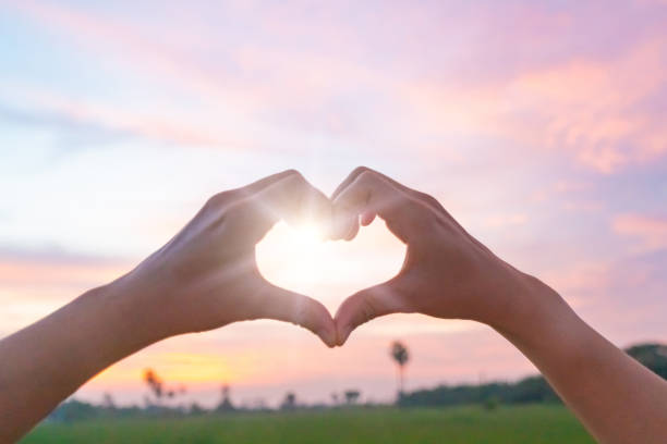 istock Woman hand do heart shape on nature blue sky background. 1315802964