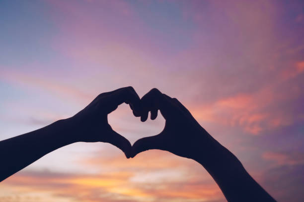 istock Woman hand do heart shape on nature blue sky background. 1315802982