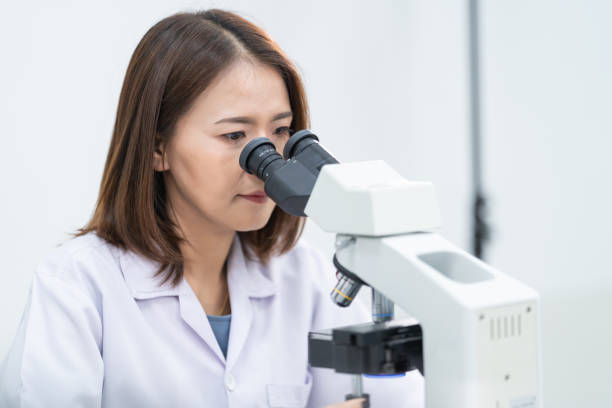 istock A young scientist woman in a laboratory coat looking through a microscope in a laboratory to do research and experiment. Scientist working in a laboratory. Education stock photo 1315803054
