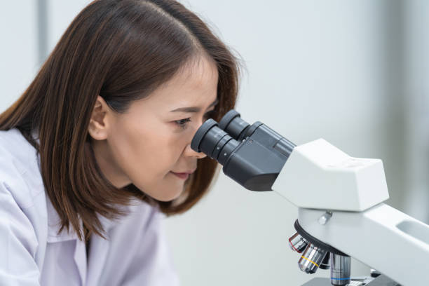 istock A young scientist woman in a laboratory coat looking through a microscope in a laboratory to do research and experiment. Scientist working in a laboratory. Education stock photo 1315803056