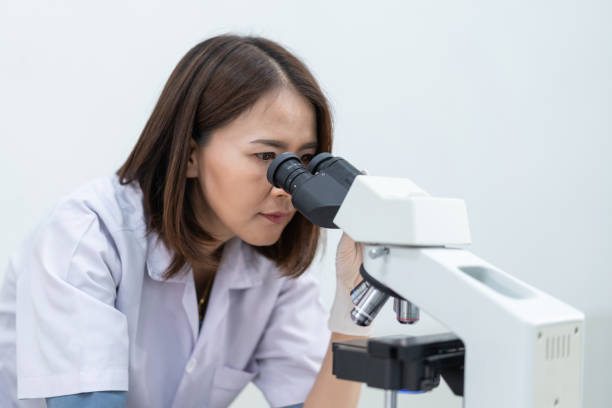 istock A young scientist woman in a laboratory coat looking through a microscope in a laboratory to do research and experiment. Scientist working in a laboratory. Education stock photo 1315804857