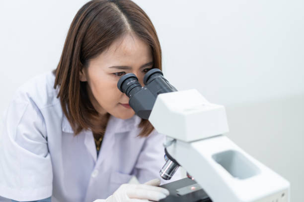 istock A young scientist woman in a laboratory coat looking through a microscope in a laboratory to do research and experiment. Scientist working in a laboratory. Education stock photo 1315805828