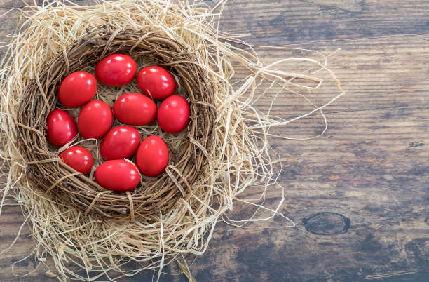 Red Eggs. Flatlay. Copy Space. Traditional red painted eggs  laid on  nest straw decor for Greek Orthodox Easter celebration. Stock Image. greek orthodox stock pictures, royalty-free photos & images