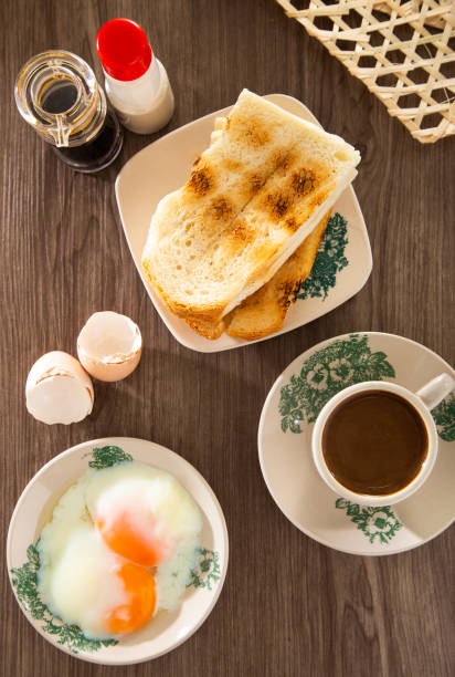 Common oriental breakfast set in Malaysia consisting of coffee, nasi lemak, toast bread and half-boiled egg Common oriental breakfast set in Malaysia consisting of coffee, nasi lemak, toast bread and half-boiled egg kopitiam egg stock pictures, royalty-free photos & images
