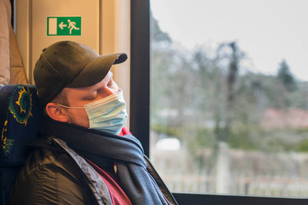 hombre dormido con máscara protectora médica en tren - schlafend fotografías e imágenes de stock