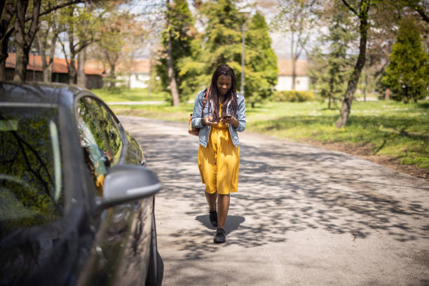 istock Young african woman walking through park and using phone 1315816620