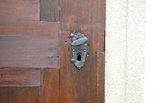 This is an old massive door with decorative door handle and lock, all still functional