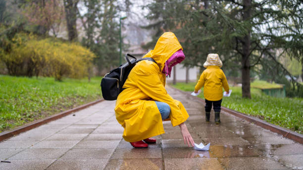 istock Child playing with paper boats in water puddle 1315819465