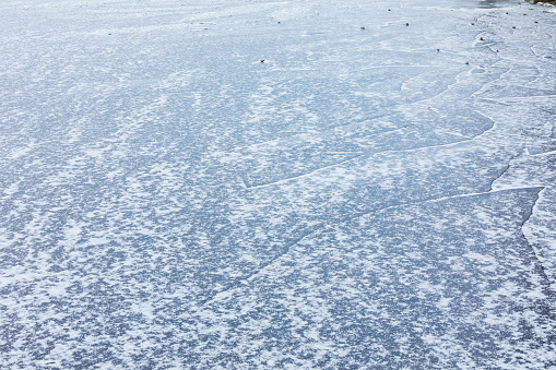 Frozen lake surface and snow at winter day