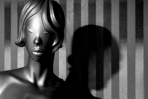 A female mannequin is with her shadow on the wall with a striped pattern.