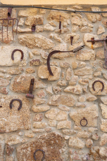 istock Various old homemade utensils along with rusty tools used in agriculture hanging on the exterior wall of a dwelling 1315829806