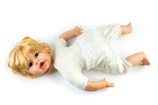 Cute old toy doll with severed head - isolated against white background
