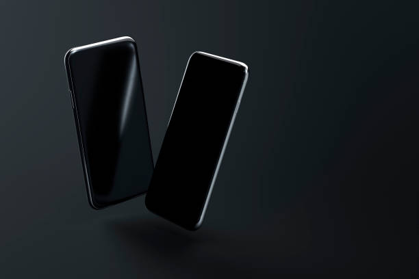 istock Two smartphones with blank screen on dark background 1315851464