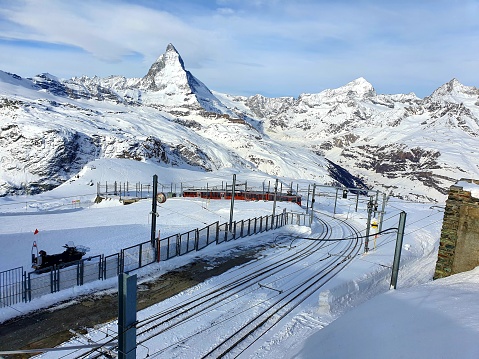 The Matterhorn in the canton of valais with an altitute of 4'478 m is one of the bst known mountain peaks in the world. The near-symmetric pyramidal peak was captured during winter season. The image was captured during winter season and it shows the Peak and the Gornergrat Railway.