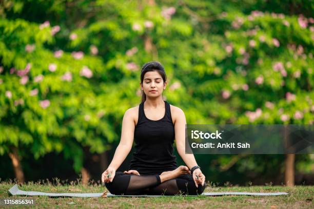 Young Woman Meditating Outdoors At Park Stock Photo - Download Image Now - Yoga, Meditating, Zen-like