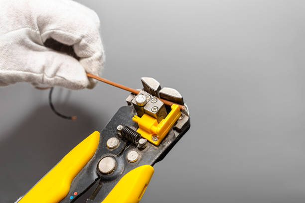 istock An electrician uses a automatic insulation stripper to prepare the phase cable for installation. 1315859139