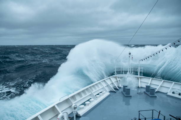 During rough seas, the bow of the expedition cruise ship MS Bremen (Hapag-Lloyd Cruises) collides with large waves, creating a spectacular splash and spray During rough seas, the bow of the expedition cruise ship MS Bremen (Hapag-Lloyd Cruises) collides with large waves, creating a spectacular splash and spray, near South Georgia Island, Antarctica ships bow photos stock pictures, royalty-free photos & images