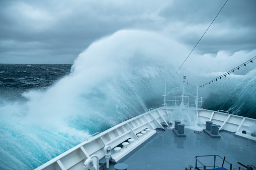 During rough seas, the bow of the expedition cruise ship MS Bremen (Hapag-Lloyd Cruises) collides with large waves, creating a spectacular splash and spray, near South Georgia Island, Antarctica