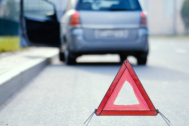 istock Emergency stop sign in background with broken down car. 1315865232