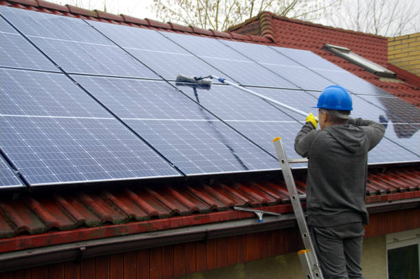 istock A man on a ladder cleaning solar panels 1315866397