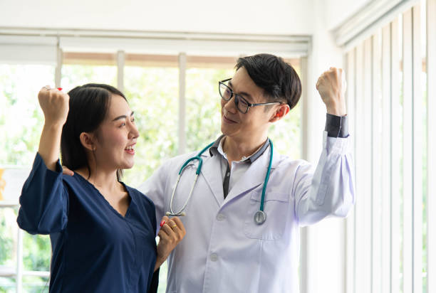 Concepto de salud mental. Médico asiático animó a jóvenes pacientes hermosos. Paciente sentirse feliz después de recibir consejos del ficsólogo. - foto de stock