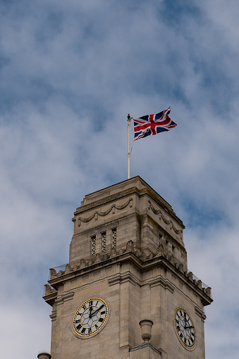 Union Flag also known as the Union Jack, flying on Barnsley town hall clock tower in South Yorkshire