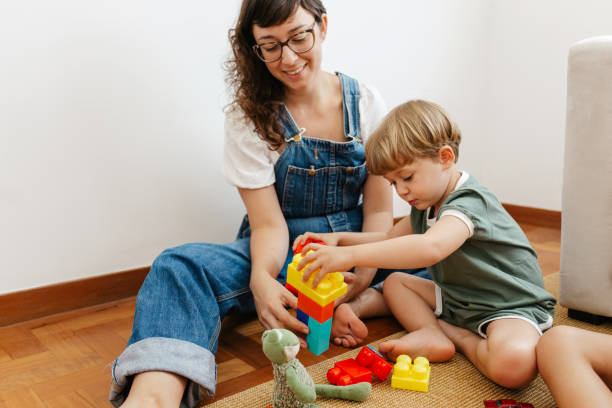 istock Child playing colorful blocks game with mother 1315870584
